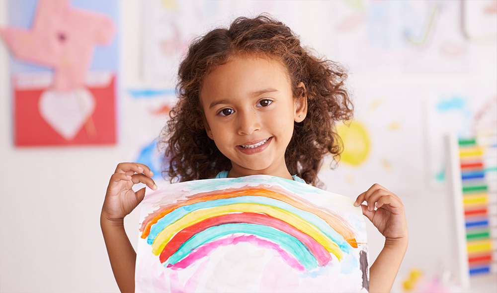 Youth art programs. Child with a rainbow painting