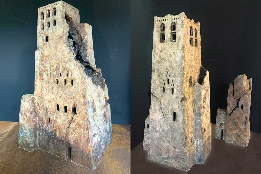 An image of two sculptures of towers carved from rock