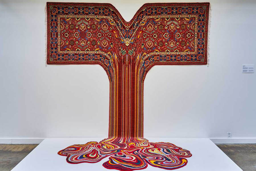 Artwork: traditional multicolored oriental carpet with the middle fabric dripping down into a puddle on the ground. Faig Ahmed, Gautama, 2017, Handmade wool carpet, 112