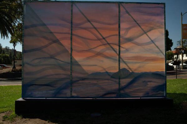 Back of "Dreams of Bayanihan" by Camille Hoffman. Back view, illuminated by sunset. Outline painting of Morro Rock at sunset
