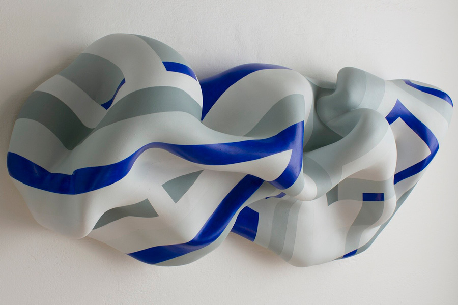 "Electric Storm" by Marela Zacarias. A wall-hung sculpture created in waves with geometric blue, white, and gray stripes