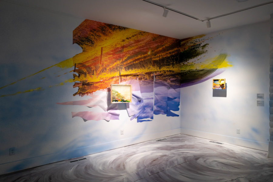 View of the east wall of the Gray Wing, showing Camille Hoffman's artwork in "See and Missed." An image of golden vineyards are hung upside down on vinyl strips that are torn at the bottom (sky), with painting emanating from the sides