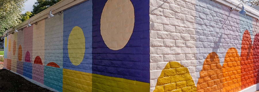 In progress: Leah Rosenberg's "SLO(W) Rainbow" mural on SLOMA's exterior. Colorful blocks with minimalistic designs showing a sunset and moon rise.