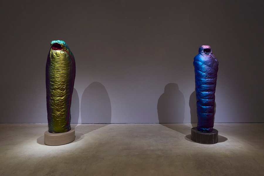 Two of Adam Parker Smith's "sleeping bag" sculptures, standing upright similar to an ancient Egyptian sarcophagus