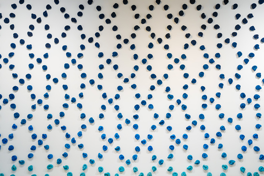 Ombre dark-to-light blue ship's knots in a crosshatch pattern on a white wall