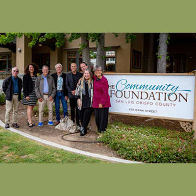 (L to R) Chuck Crotser, Mayor Erica A. Stewart, John Dunn, Pierre Rademaker, City Manager Derek Johnson, Kevin Harris, Leann Standish and Heidi McPherson stand next to each other in front of the Community Foundation SLO County building