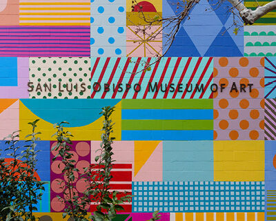 Detail of "SLO(W) Rainbow" by Leah Rosenberg, SLOMA's 2023 mural project. Closeup of the creekside wall with squares filled with different patterns and colors