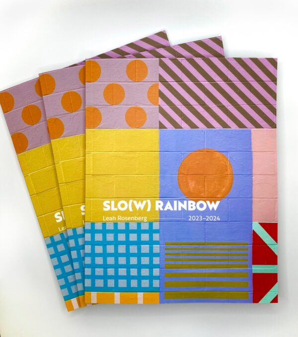 Three catalogs depicting a colorful wall covered in patterns