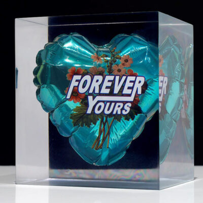 Adam Parker Smith artwork. A sculpture depicting a metallic balloon with "Forever Yours" on the front, encased in a clear resin cube