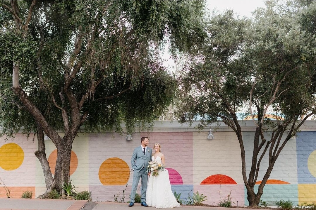 Wedding couple in front of SLOMA's 2023-2024 mural