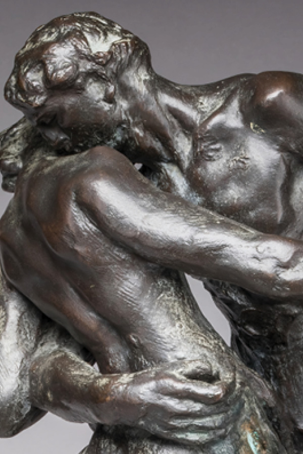 Detail of a bronze sculpture depicting a dancing couple, spinning together on a diagonal axis in a close embrace