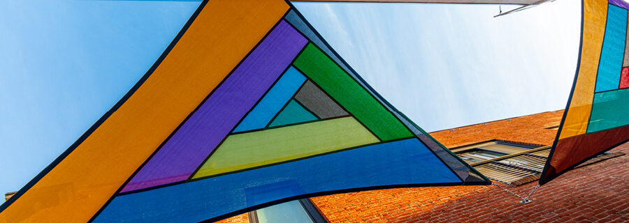 Underside photograph of a colorful sailcloth suspended overhead