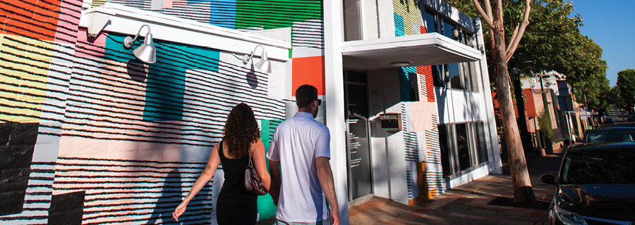 2024 Impact Report: two people hold hands as they walk by the museum