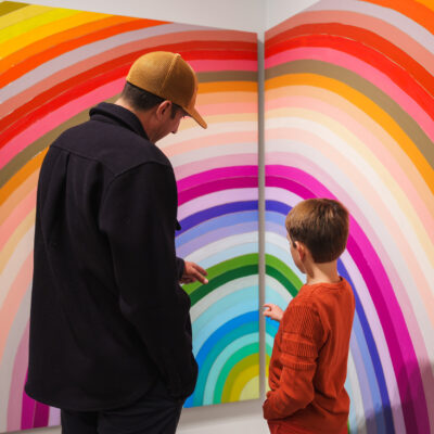 hours A father and son examine a rainbow artwork
