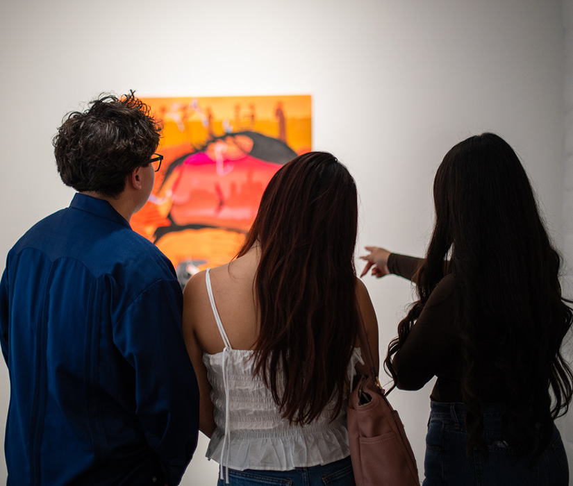 SLOMA tour Three people looking at an artwork, from behind
