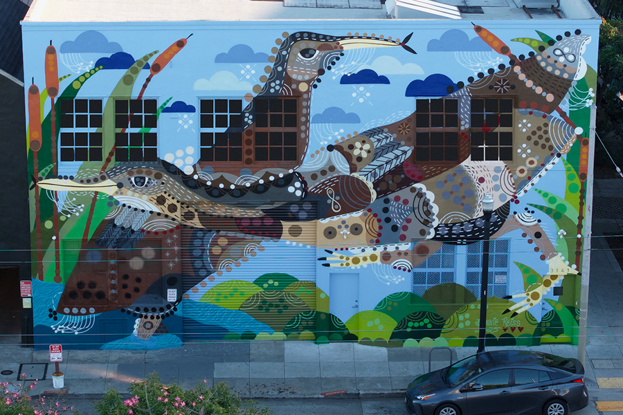 A colorful mural on a two-story building depicting aquatic birds