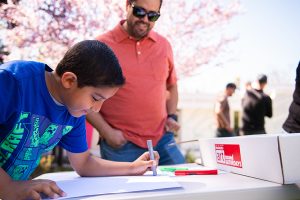 Art classes. Camps. Community events. A kid completes an art project as his dad observes